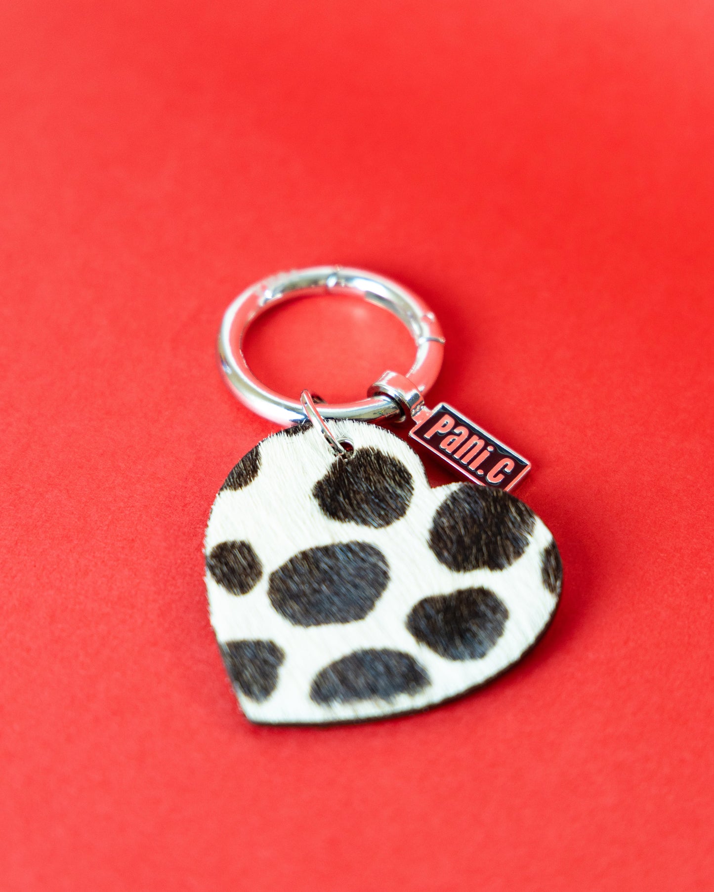 Heart-shaped keychain with Dalmatian pattern on a red background
